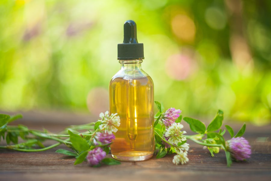 Essence of flowers on table in beautiful glass jar